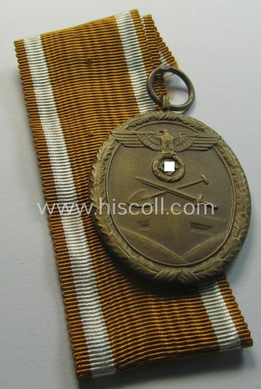 Medal-set: 'Deutsches Schutzwall Ehrenzeichen' (aka: 'Westwall'-medal) being a non-maker-marked- and/or: 'Buntmetall'-based specimen that comes mounted onto its period- (and neatly folded ie. pre-confectioned) ribbon (ie. 'Bandabschnitt')