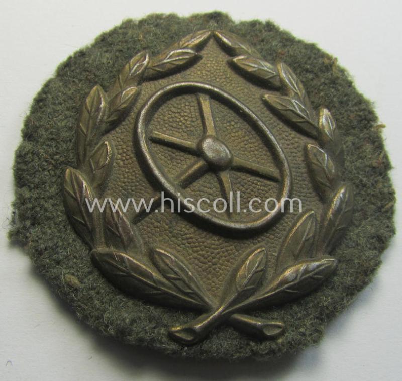 WH (Heeres o. Waffen-SS) so-called: 'Kraftfahrbewährungs-Abzeichen in Bronze' (or: bronze-class drivers'-proficiency-badge) that comes mounted onto its piece of field-grey-coloured wool as most certainly issued- and/or clearly worn, condition