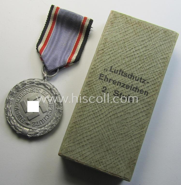 Attractive, light-weight (ie. typical aluminium-based) medal as was intended for air-raid wardens 2nd. class (or: 'Luftschutz-Ehrenzeichen 2. Stufe') that comes stored in its period, dove-grey-coloured etui