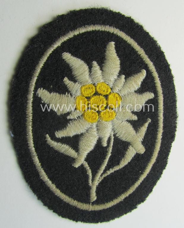 Neat - and I deem truly used and/or worn! - Waffen-SS-pattern, black-coloured sleeve-insignia (ie. 'Ärmelabzeichen') depicting an: 'Edelweiss'-flower as used by the various 'Gebirgsjäger'- (ie. mountain-troops-) related divisional-staff