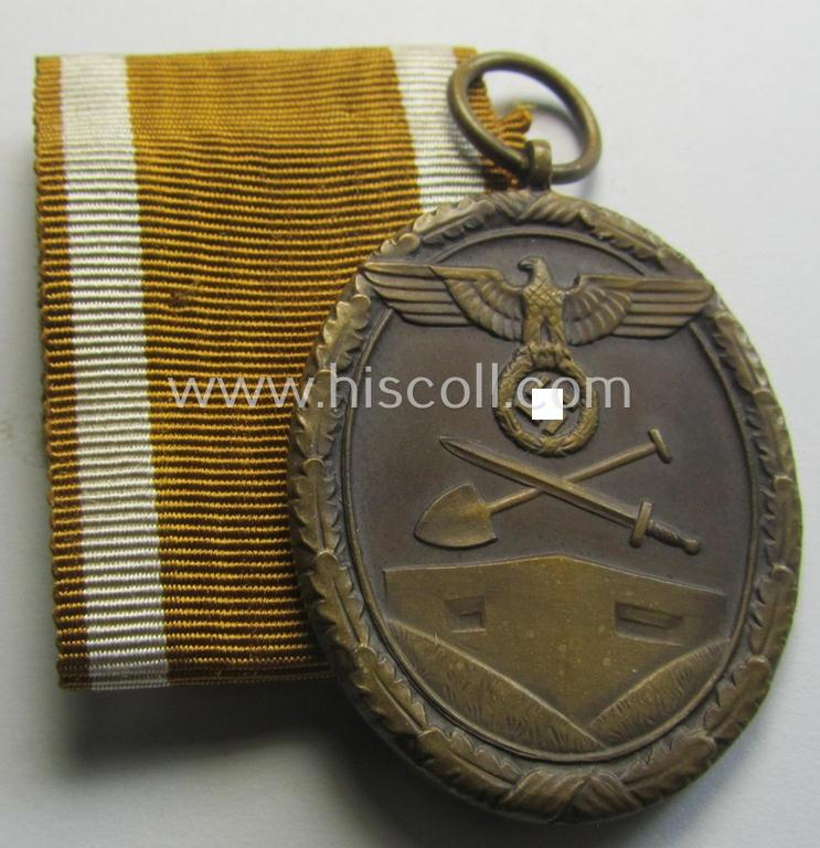 Medal-set: 'Deutsches Schutzwall Ehrenzeichen' (aka: 'Westwall'-medal) being a non-maker-marked- and/or: 'Buntmetall'-based specimen that came together with its period- (and neatly folded ie. pre-confectioned) ribbon (ie. 'Bandabschnitt')