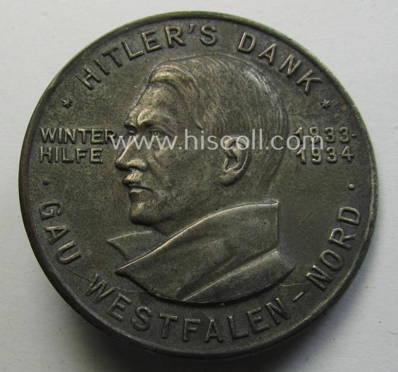 Commemorative - zinc-based- and/or silver-coloured - N.S.D.A.P.- (ie. WHW-) related 'tinnie', being a maker- (ie. 'Paulmann u. Crone'-) marked example depicting a portrait of Adolf Hitler surrounded by the text: 'Hitlers' Dank - Gau Westfalen Nord'