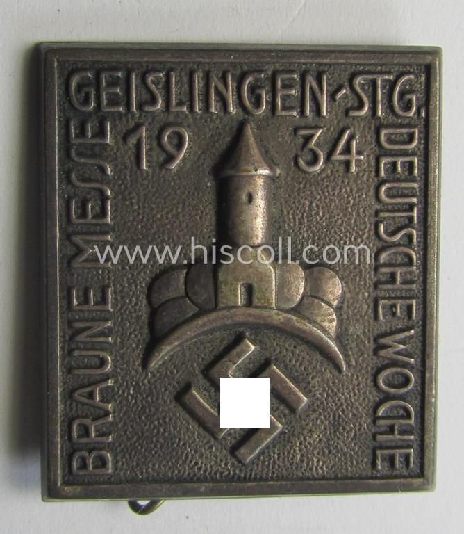 Early-period, silver-coloured- and/or 'Buntmetall'-based, N.S.D.A.P.-related day-badge (ie. 'tinnie' or: 'Veranstaltungsabzeichen') being a commemorative example that is entitled: 'Braune Messe - Deutsche Woche - Geislingen-Stg. - 1934'