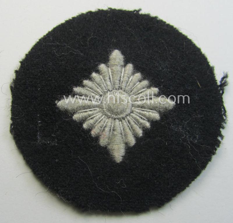 Waffen-SS- (ie. Heeres-'Panzer'-) type, machine-embroidered rank-badge (or: roundel) as was executed on smooth-type- and black-coloured wool as was intended for an: 'SS-Oberschütze' (ie. Heeres 'Oberschütze')