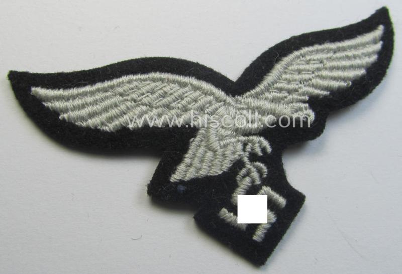 Attractive, WH (Luftwaffe) cap-eagle (being a 'standard-issue'-pattern example as executed onto a black-coloured and woolen-based background and as such intended for usage on the black-coloured work- ie. 'HG'-related side-caps ie. 'Schiffchen')