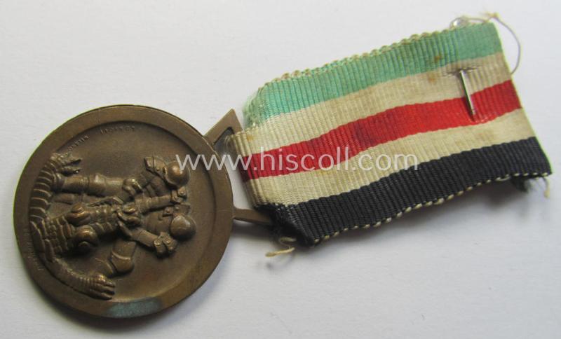 Attractive, golden-bronze-coloured- (and I deem 'Buntmetall'-based-) example of a: 'Deutsch-Italienische Feldzugsmedaille' (or: German-Italian campaign-medal) that comes mounted onto its (regular-sized) piece of original (and minimally faded!) ribbon