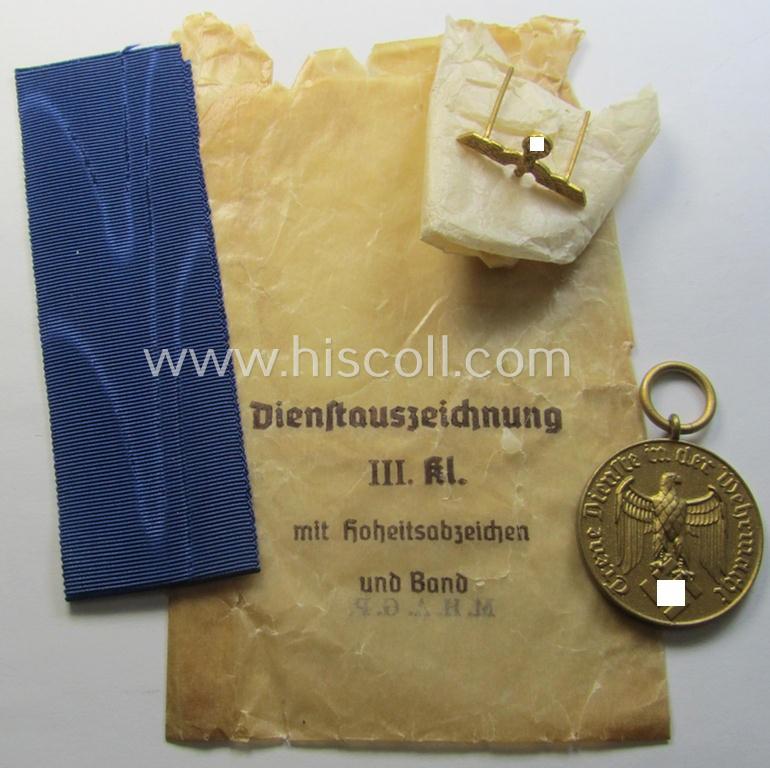 Attractive - and unusually seen! - WH (Heeres o. KM) bright-golden-toned, 'WH-DA der 3. Klasse für 12 Jahre Dienstzeit' that comes with its accompanying ribbon (ie. 'Bandabschnitt') and eagle-device as stored in its period 'Cellophan'-based pouch