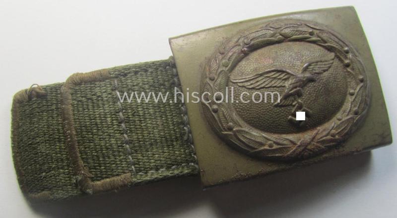 Rarely found WH (Luftwaffe) 'tropical-issued' belt-buckle being a non-maker-marked, beige-tan-coloured example that comes mounted onto its original, greenish-coloured- (and/or: 'webbing'-based-) tab